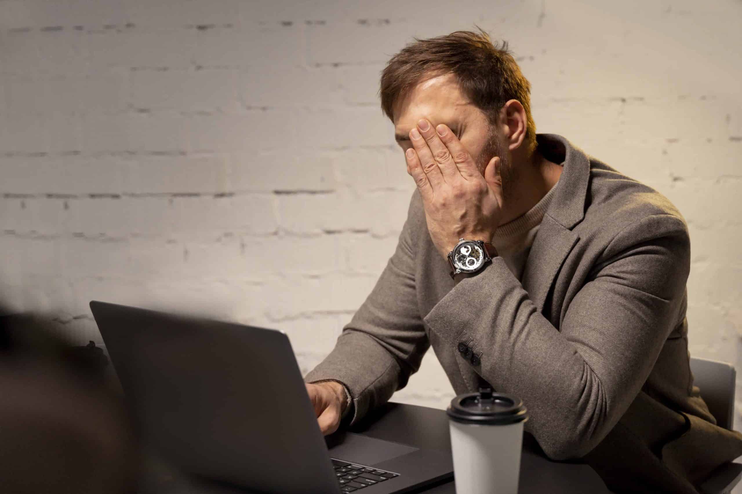 Frustrated employee struggling with Microsoft Dynamics interface on laptop, symbolizing poor CRM adoption and low system ROI